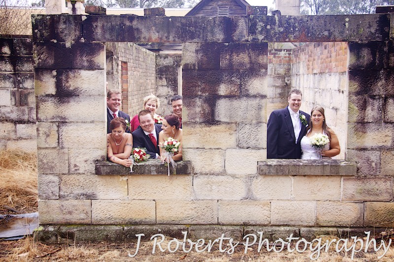Couple and bridal party in windows of old sandstone building - wedding photography sydney